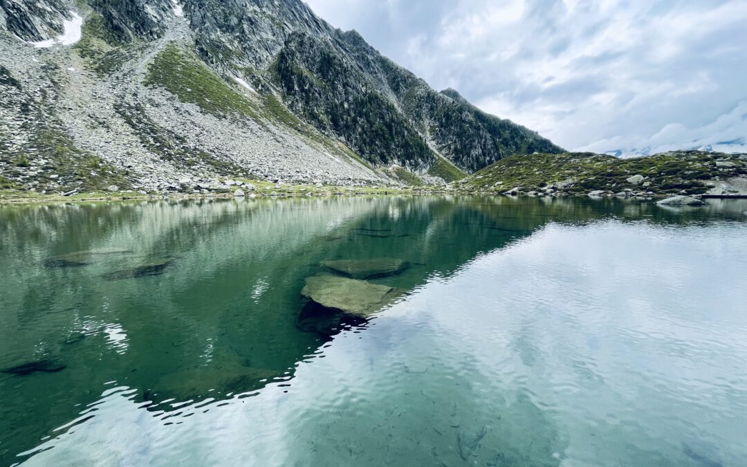 Klarer See vor einem eindrucksvollen Gebirge.